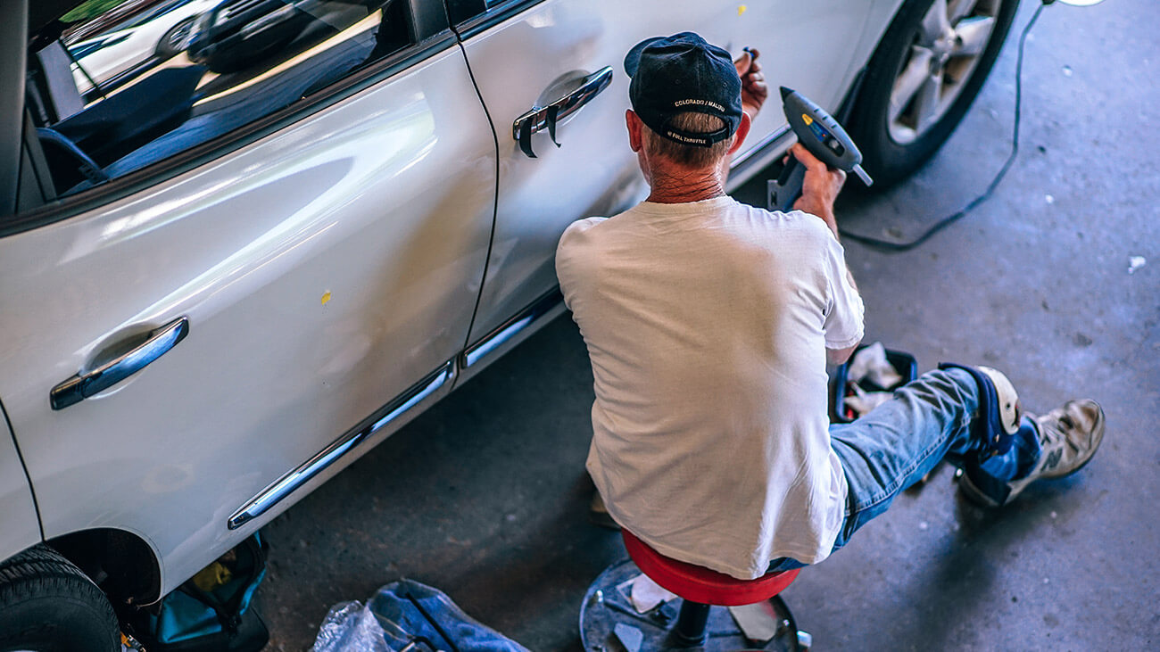 Muž opravuje auto